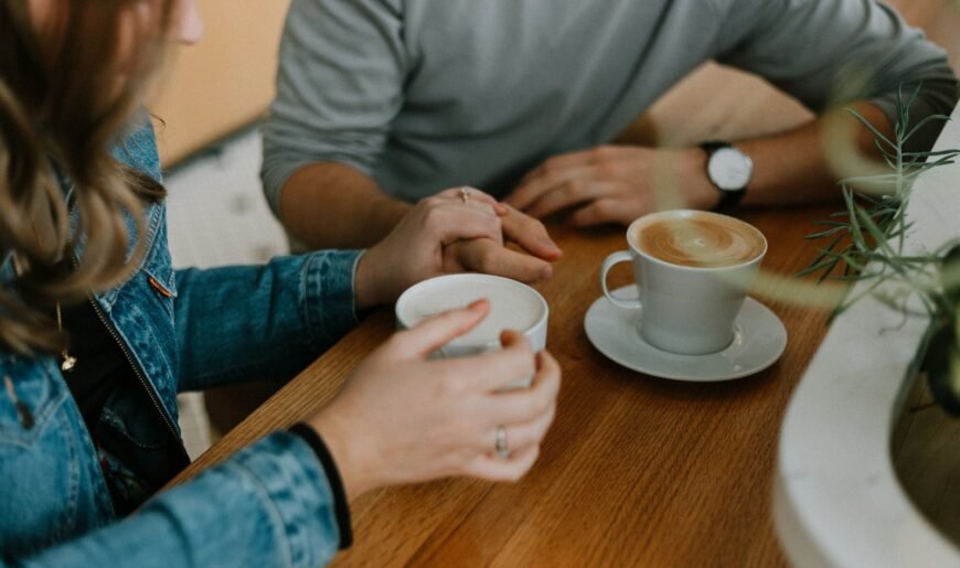 Deux tasses de café posées côte à côte sur une table en bois, symbole d'un rendez-vous à deux