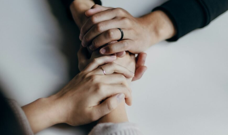 Deux personnes adultes se tenant la main sur une table, geste de tendresse et de soutien dans le couple