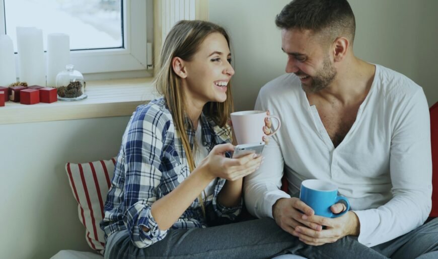 Couple adulte souriant qui discute en buvant un café le matin, symbole du dialogue sur le désir